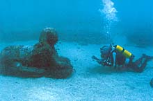 Diver examining submerged Sphinx off the coast of Alexandria, Egypt